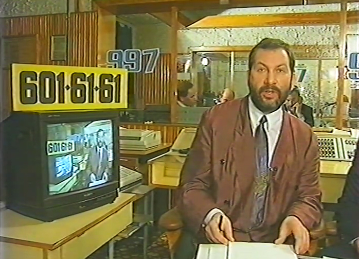 zdjęcie: mężczyzna w garniturze w biurze, obok niego stary telewizor
