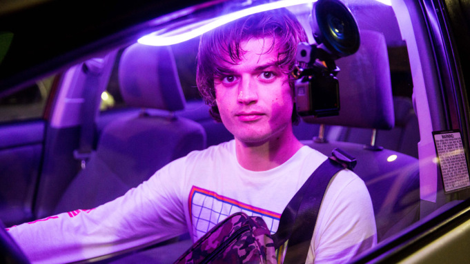 zdjęcie: mężczyzna znajduję się w samochodzie oświetlonym fioletowym światłem